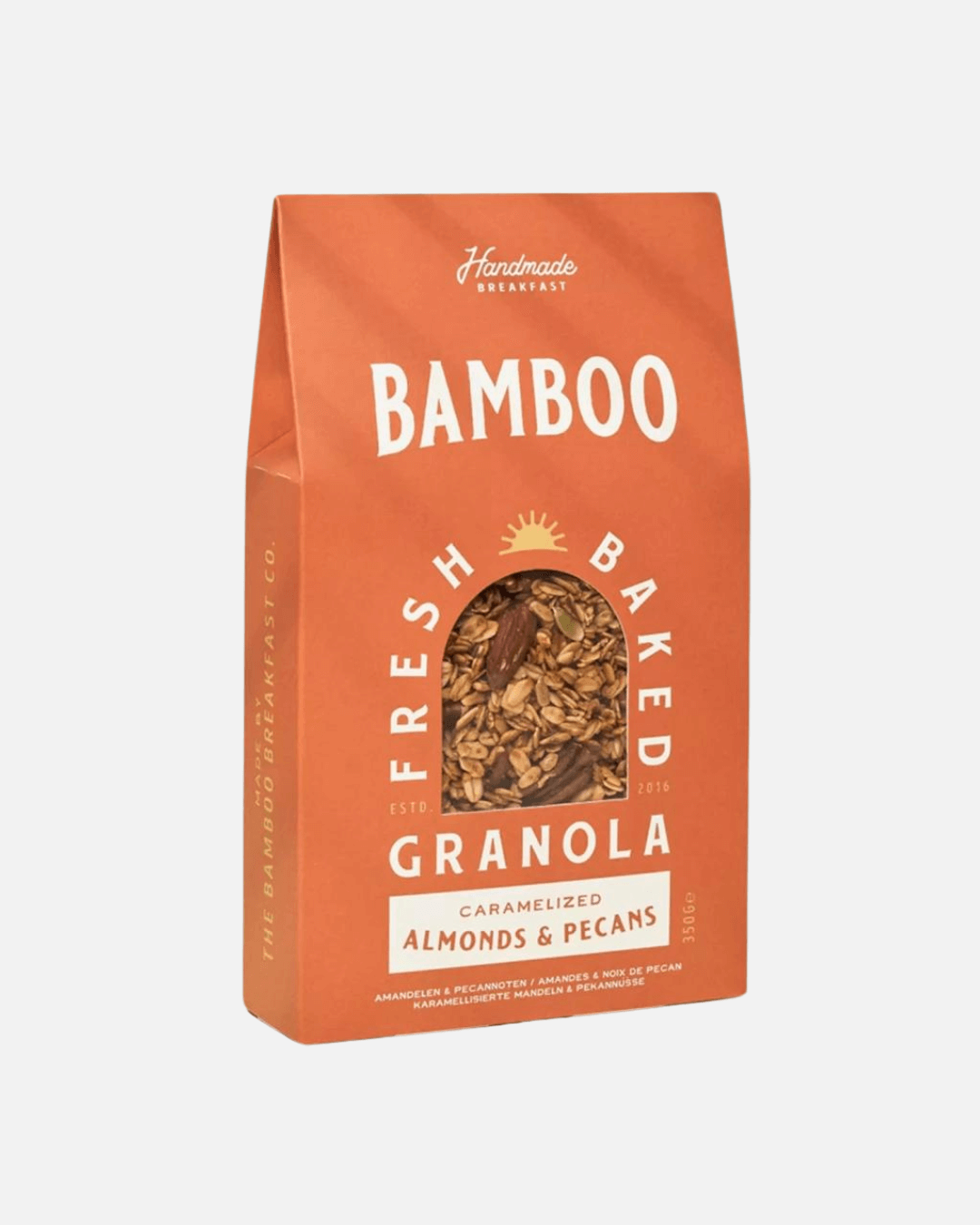 Eine orangefarbene  Packung Bamboo Breakfast handgemachtes Granola mit karamellisierten Mandeln und Pekannüssen.