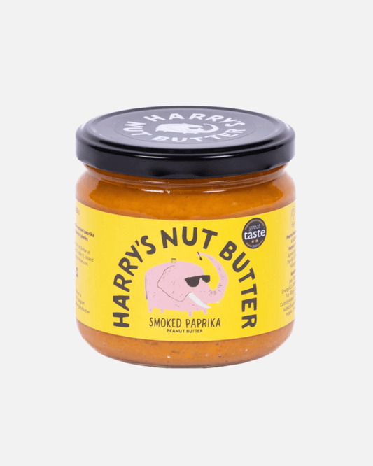 Glas Harry's Erdnussbutter mit geräuchertem Paprika, gelbes Etikett und schwarzer Deckel, vor weißem Hintergrund.